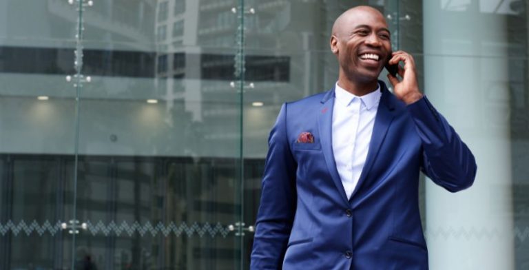 A man in a suit talking on a cell phone.