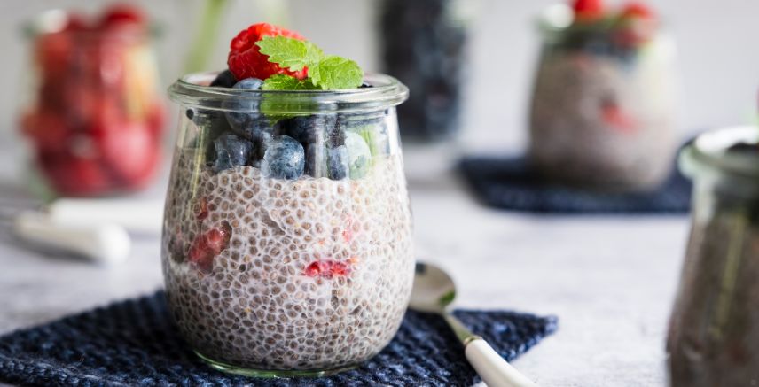 A jar of chia seed pudding ,with blueberries and strawberries on top.